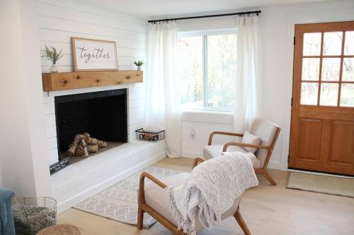 a living room with a fireplace and two chairs at Lake House get away in Whitsett
