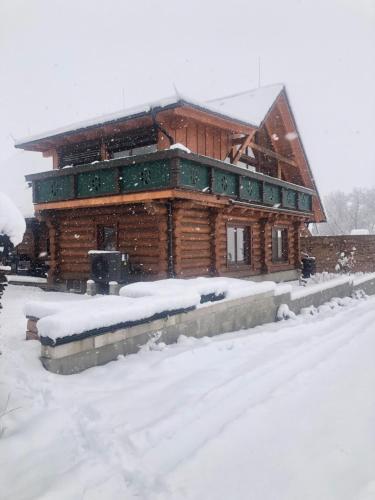 una cabaña de troncos en la nieve con nieve en Zrub Kriváň Drevená chata s výhľadom na Tatry, en Závažná Poruba