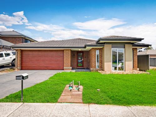 a house with a lawn in front of it at Cranbourne Cottage in Narre Warren South
