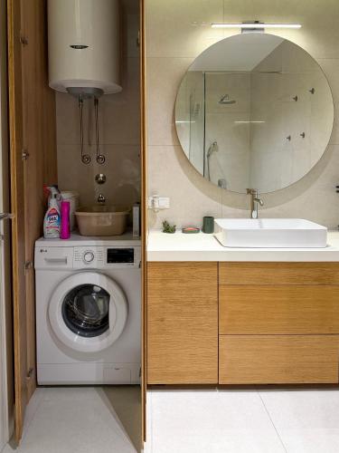 a bathroom with a sink and a washing machine at Seaview Apartment in Bečići