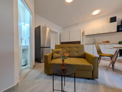 un salon avec un canapé et une table dans l'établissement Cozy Studio w Floor Heating & King Size Bed, à Sesvete
