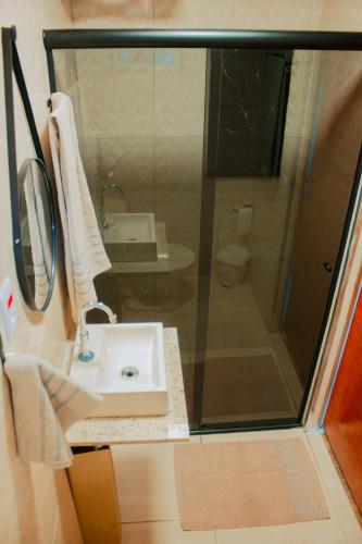 a bathroom with a sink and a glass shower at Villa de Recriary in Campos do Jordão