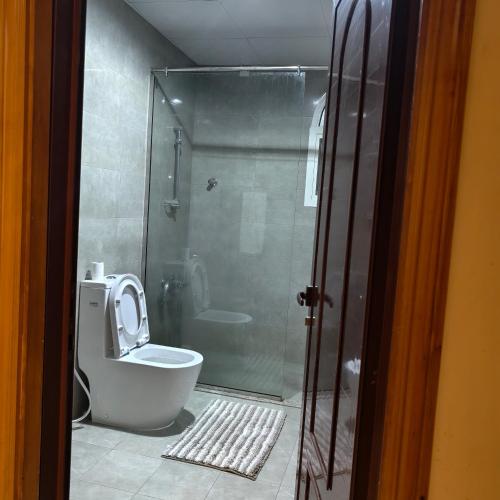 a bathroom with a toilet and a glass shower at doge villa 3 in Dubai