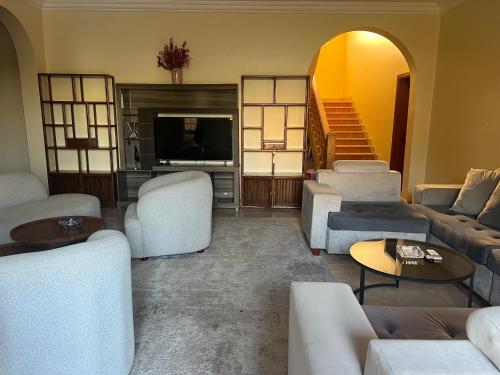 a living room with white couches and a television at doge villa 3 in Dubai
