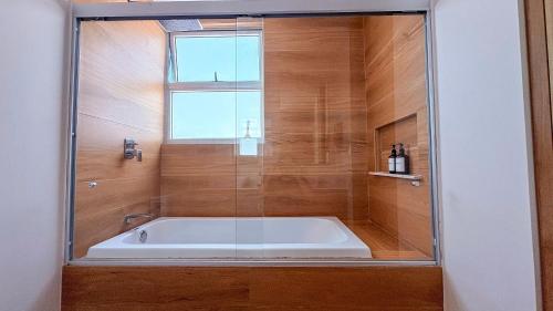 eine Badewanne im Bad mit Fenster in der Unterkunft Condominios de lujo en el corazón de la Zona Dorada en Camino Al Mar. in Mazatlán