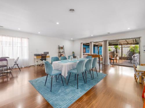 a dining room with a table and blue chairs at Cranbourne Cottage in Narre Warren South