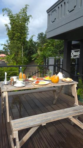 una mesa de picnic con comida en la cubierta en The Next Door, en Kandy