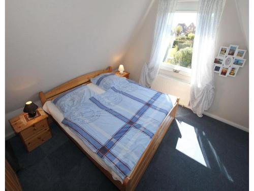 a bedroom with a bed with a plaid blanket at Ferienhaus Seeschwalbe in Dornumersiel in Dornumersiel