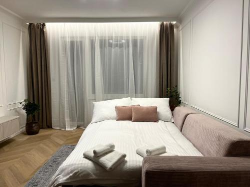 Un dormitorio con una cama grande con toallas. en Stylish Modern-Victorian Apartment with Balcony, en Staré Mesto