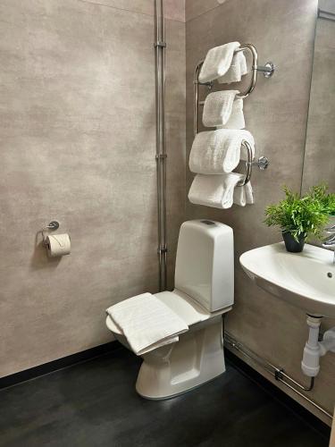 a bathroom with a toilet and a sink and towels at Fridhemsgatan City Stay in Mora