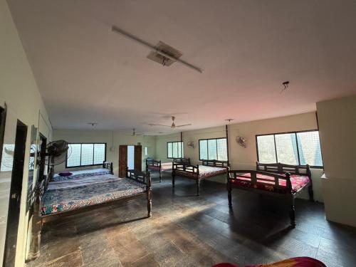 une chambre avec trois lits dans une pièce avec fenêtres dans l'établissement Green Waves Resort, à Nagaon