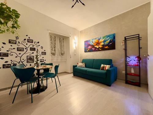 een woonkamer met een blauwe bank en een tafel bij Al Kicco D'oro - Intero appartamento in Lido di Ostia