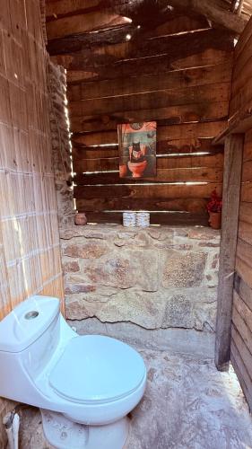 a bathroom with a toilet in a wooden building at El Chiringuito, Mermejita in Mazunte