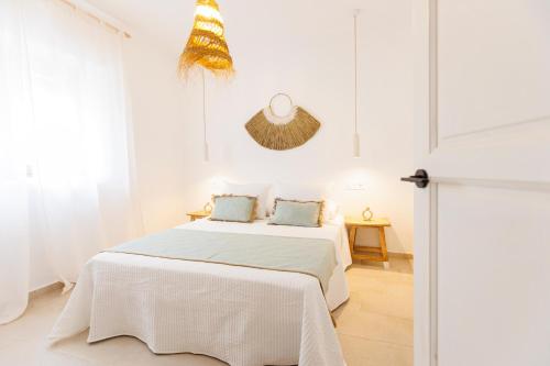 ein weißes Schlafzimmer mit einem Bett mit weißer Bettwäsche in der Unterkunft Casa el corralón in Salobreña