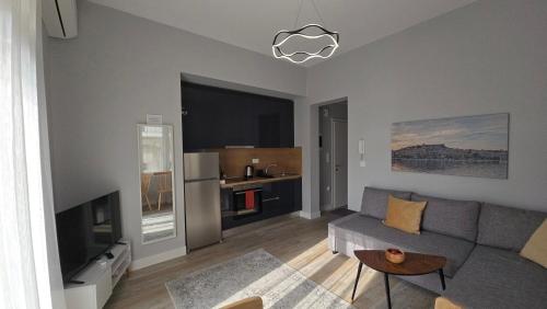 un salon avec un canapé et une télévision dans l'établissement KYANA Luxury KVA II, à Kavala