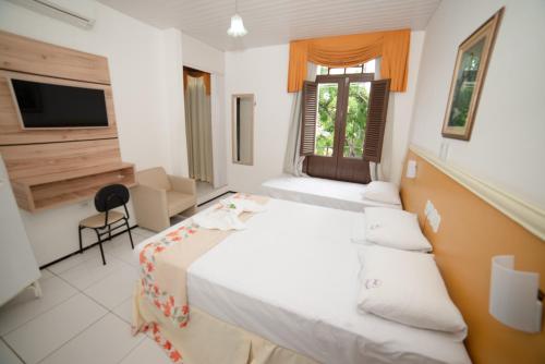 a hotel room with a bed and a television at Hotel Villa Real in Crato