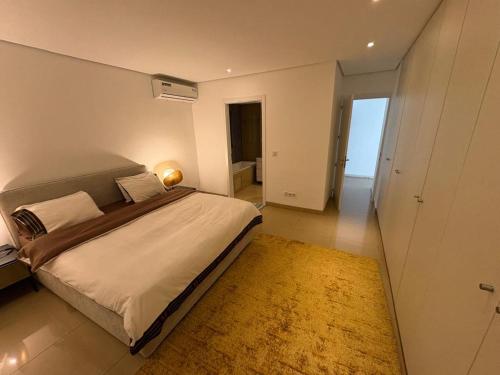 une chambre avec un grand lit et un tapis dans l'établissement Waterfront - B luxury, à Dakar