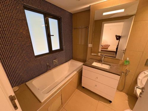 une salle de bain avec une baignoire, un lavabo et un miroir dans l'établissement Waterfront - B luxury, à Dakar
