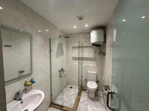 een badkamer met een douche, een toilet en een wastafel bij The Tree Pyramids Inn in Caïro