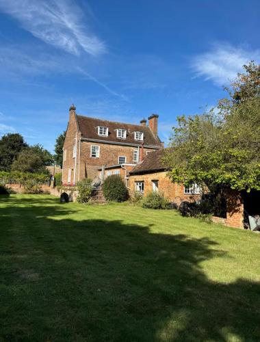 a large brick house with a large grass yard at The Grange, Northill in Northill
