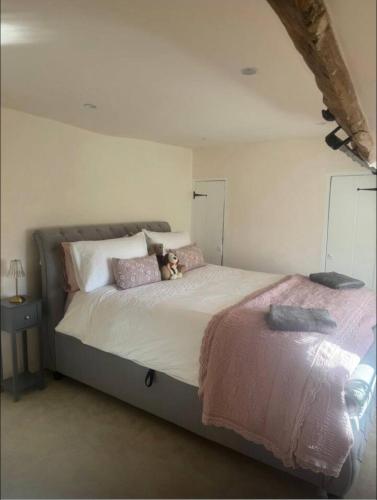 a bedroom with a bed with a teddy bear on it at The Grange, Northill in Northill