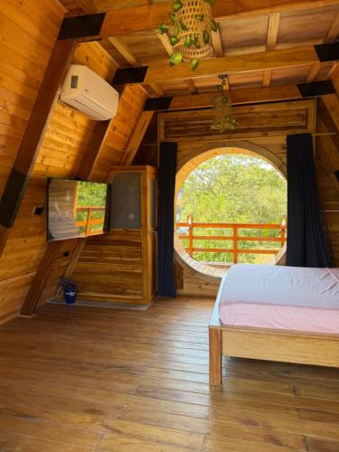 a bedroom in a wooden cabin with a window at Refugio en el Mar in Arboletes