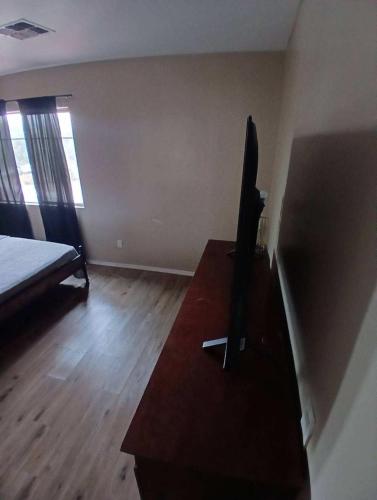 a living room with a tv on a dresser and a bed at West Phoenix Value Room 4 Bennet in Phoenix