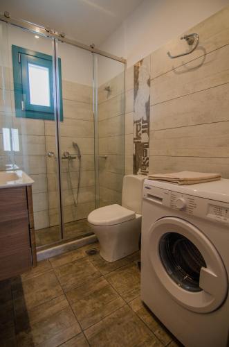 a bathroom with a washing machine and a toilet at Ios Sea View in Ios Chora