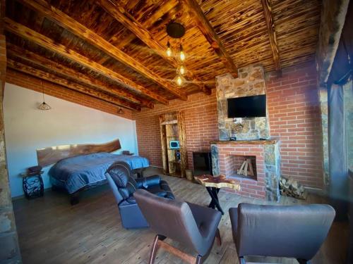 une chambre avec un lit et un mur de briques dans l'établissement Cabañas Quinta Áthas, à Huasca de Ocampo