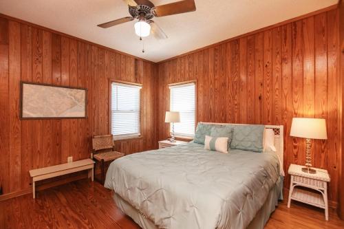1 dormitorio con 1 cama y paredes revestidas de madera en M.S. Whaley, en Edisto