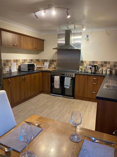 a kitchen with two wine glasses on a wooden table at The cottage in Bury Saint Edmunds