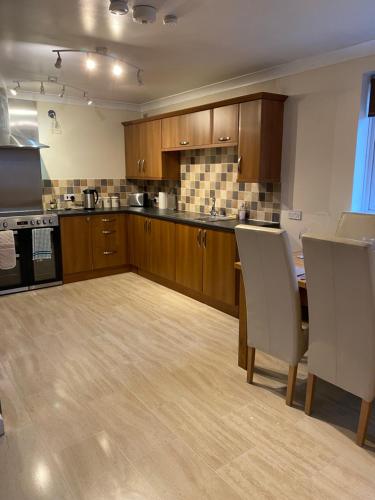 a kitchen with wooden cabinets and a table and chairs at The cottage in Bury Saint Edmunds