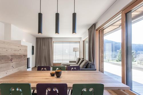 a dining room with a large wooden table and chairs at Hubertus Logis Apartments in Brixen im Thale