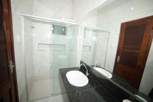 Un baño blanco con lavabo y ducha en Hotel Villa Real, en Crato