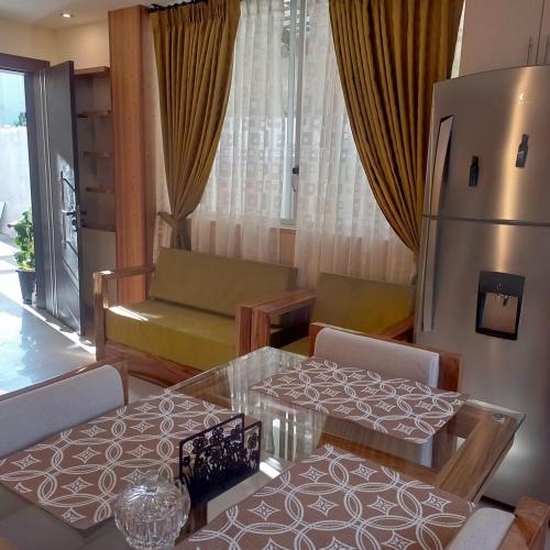 un soggiorno con 2 tavoli e un frigorifero di Departamento de 2 dormitorios en la Victoria, cerca de las Universidades con garaje gratis a Ibarra