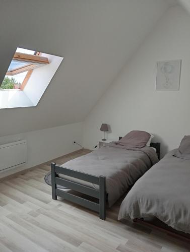 une chambre blanche avec deux lits et une fenêtre dans l'établissement Le Haut de Clarques, à Clarques