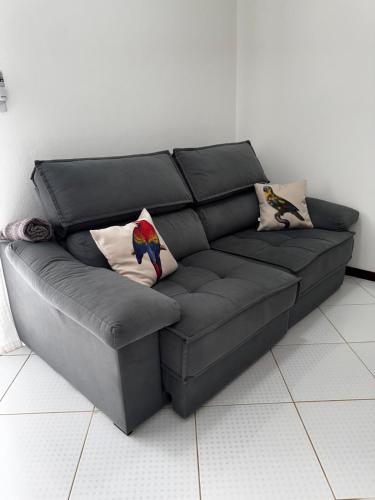 ein schwarzes Ledersofa im Wohnzimmer in der Unterkunft Casa Okê Paraty in Paraty