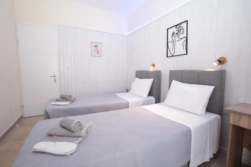 deux lits dans une chambre aux murs blancs dans l'établissement Corfu Dream Fani, à Ýpsos