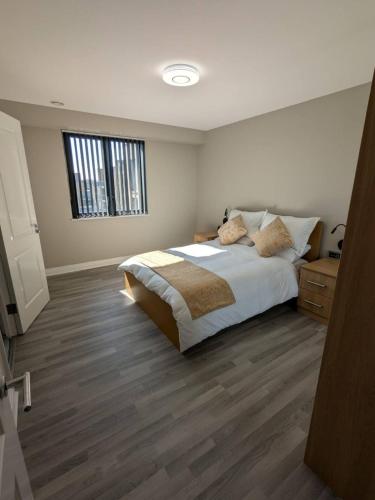 a bedroom with a large bed and a window at London Heathrow Apartment - West Drayton in Yiewsley