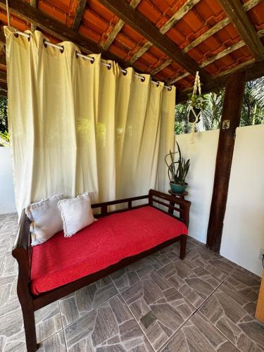 eine Bank in einer Veranda mit einem Vorhang in der Unterkunft Casa Okê Paraty in Paraty