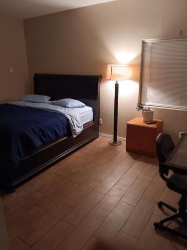 a bedroom with a bed and a lamp and a desk at West Valley King Room 94th in Phoenix