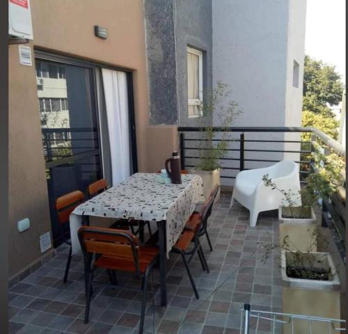 a patio with a table and chairs on a balcony at Departamento en Alquiler en Carlos Paz in La Porteña