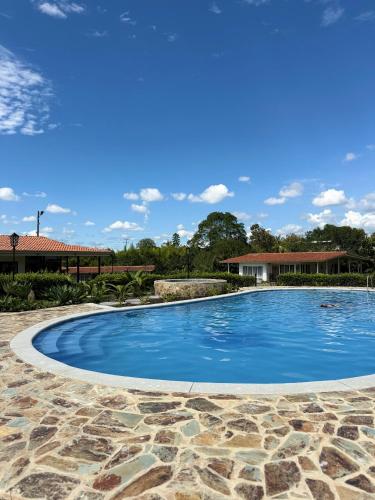 a swimming pool with blue water in a yard at Linaje Salvaje Hotel in Calarcá
