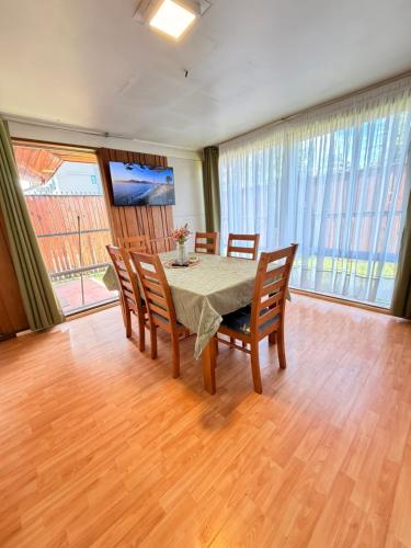a dining room with a table and four chairs at Casa Cypresses in Temuco