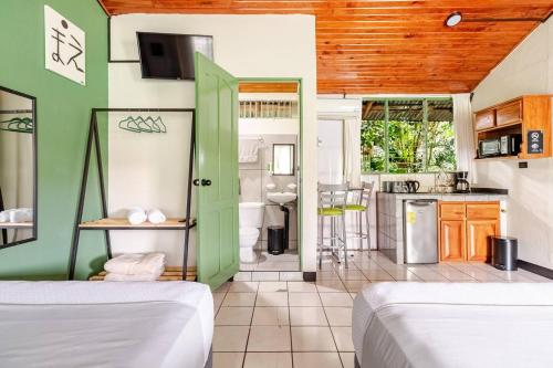 two beds in a room with a kitchen at Rio Danta in Fortuna