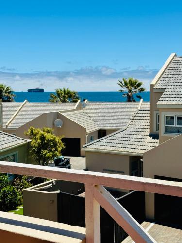 a view of houses and the ocean from a balcony at Bay Breeze in Eros Airport