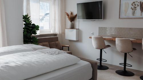 ein Schlafzimmer mit einem Bett und zwei Stühlen in der Unterkunft Ferienwohnung Alpenperle in Immenstadt im Allgäu