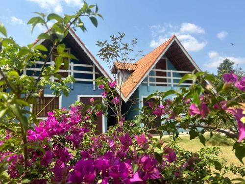 a blue house with purple flowers in front of it at Marcos Araújo in Mairinque