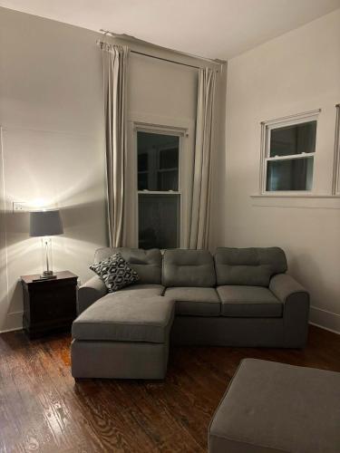 ein Wohnzimmer mit Sofa und Tisch in der Unterkunft Modern Cajun Retreat Near Downtown in Lafayette