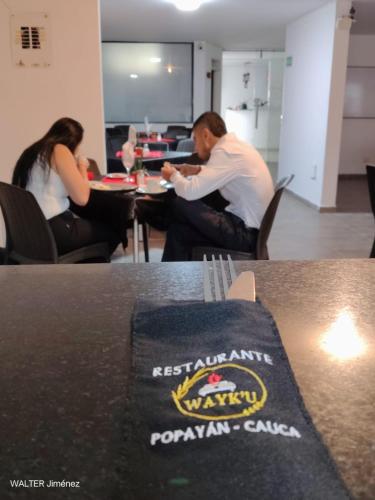 um homem e uma mulher sentados à mesa em Gran Hotel Coral em Popayan